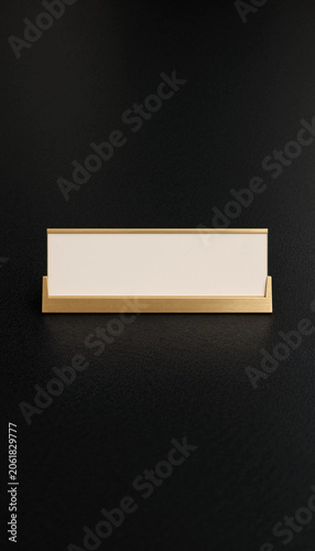 Minimalist gold and white nameplate on black background flat lay composition