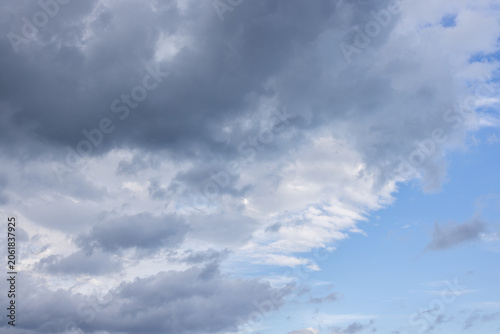 Fotografía Dark storm clouds gathering against blue sky