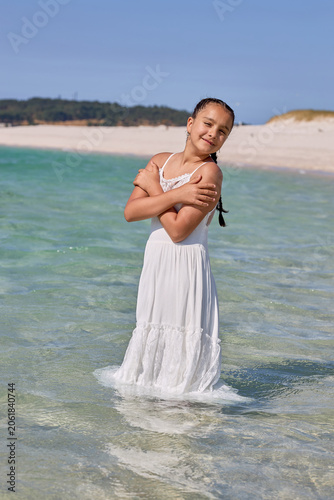 Young girl standing in shallow sea water