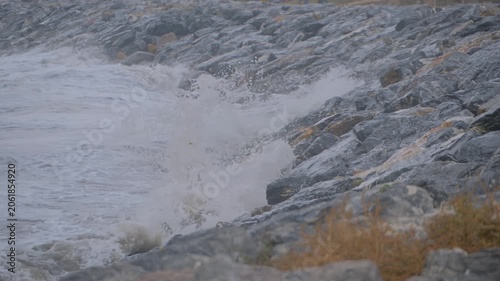 Slow motion, close up: stormy water waves of the Sea of Marmara, are crashing on rocks on the stony shore, coast - nobody, no people. Nature, element and landscape concept