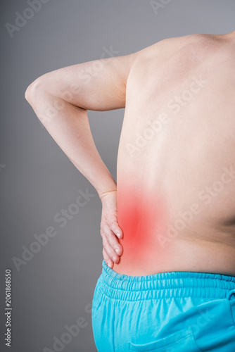 Back pain, kidney stones, inflammation and disease, man suffering from backache on grey background