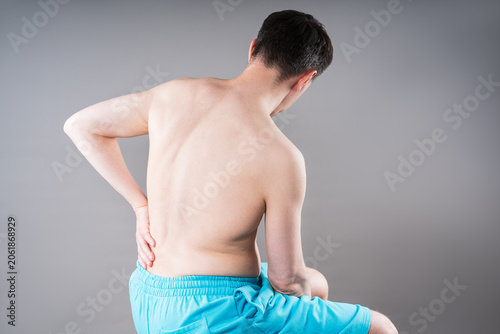 Back pain, kidney stones, inflammation and disease, man suffering from backache on grey background