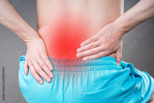 Back pain, kidney stones, inflammation and disease, man suffering from backache on grey background