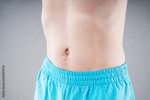 Close up of slim male torso and flat belly. Healthy digestion, weight loss, diet and body care concept