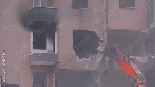 Excavator with hydraulic crusher is tearing down the old typical Turkish multi-storey apartment, residential building in Istanbul, Turkey - slow motion, demolition of building