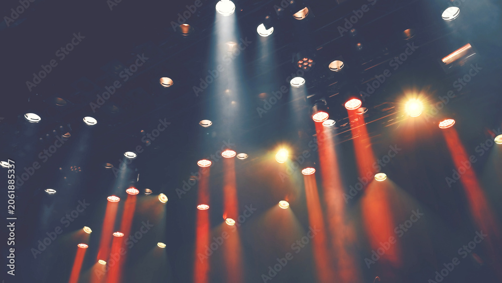 Fototapeta premium ceiling stage spotlights shines on a theater or Musical stage during the concert or show