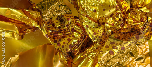 A glittery candy wrapper background. Gold wrappers with a polka dot pattern.