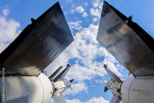 Military rockets pointing towards a blue sky