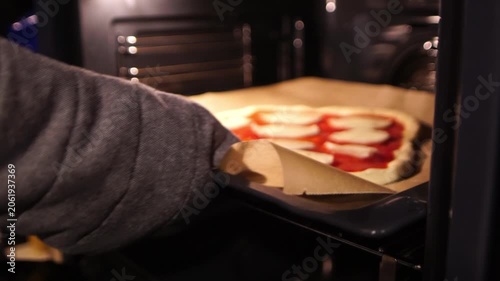 Putting a pizza in an oven