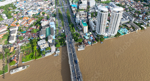 Obraz na plátně Aerial view of the Chao Phraya River in Bangkok, Thailand, showing traffic on a bridge and buildings along the riverbanks
