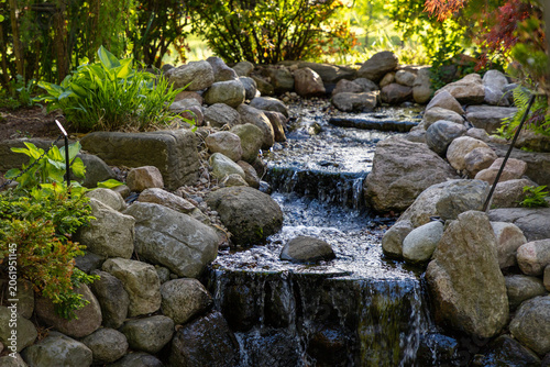 Small waterfall cascading over rocks and stones in Ornamental Gardens in Ottawa, Canada