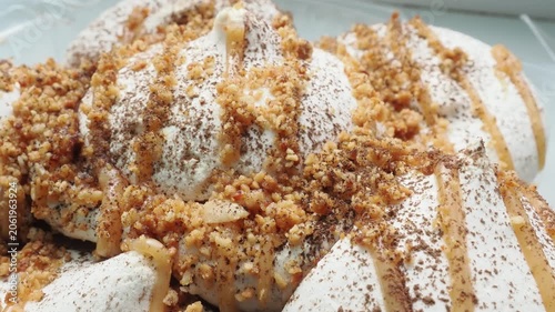 Meringue cake drizzled with caramel. A delicious dessert. A close-up of a multi-layered cake with nuts, cream, and almonds