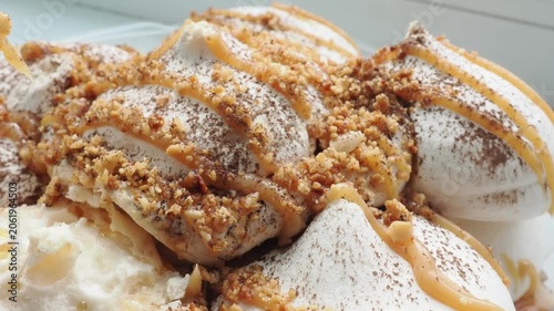Meringue cake drizzled with caramel. A delicious dessert. A close-up of a multi-layered cake with nuts, cream, and almonds