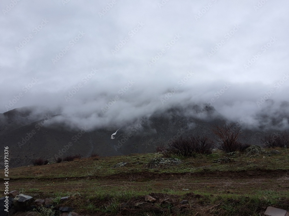 Fototapeta premium Misty Mountain Landscape With Clouds Rolling Over Hills For Nature Backgrounds