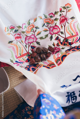 Close up of jujube dates received during Korean traditional wedding pyebaek ceremony, Close up of traditional Korean wedding Pyebaek ritual with chestnuts and jujubes on embroidered silk fabric

