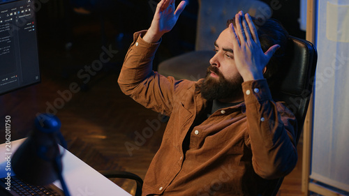 Photos Outraged software engineer perplexed by impossible to remove bugs appearing while coding on computer desktop, teleworking IT admin feeling baffled by script errors, putting hands on head