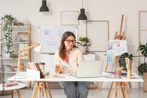 Smiling female designer wor...