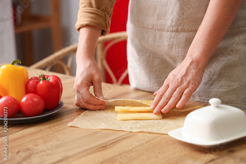 Young woman wrapping tasty ...