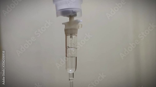 Close up of IV drip bag and tubing in a hospital setting.