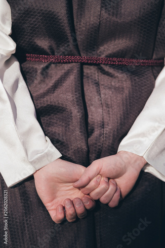 Close up of a groom in traditional Korean Hanok wedding attire holding hands behind his back
