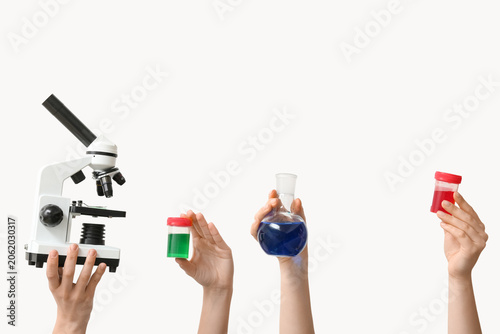 Female hands with modern microscope, laboratory glassware and jars of samples...