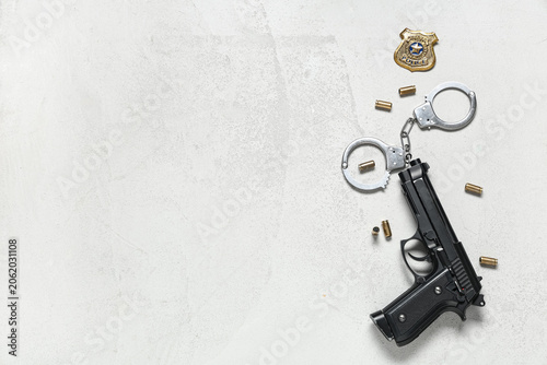 Photos Police officers shield, gun, bullets and handcuffs on light background