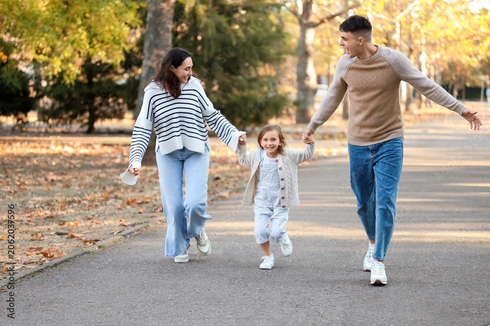 Obraz premium Happy family running together in beautiful autumn park