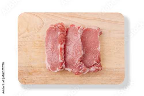 Three pieces of fresh raw pork tenderloin slices placed on wooden cutting board isolated on a white background.