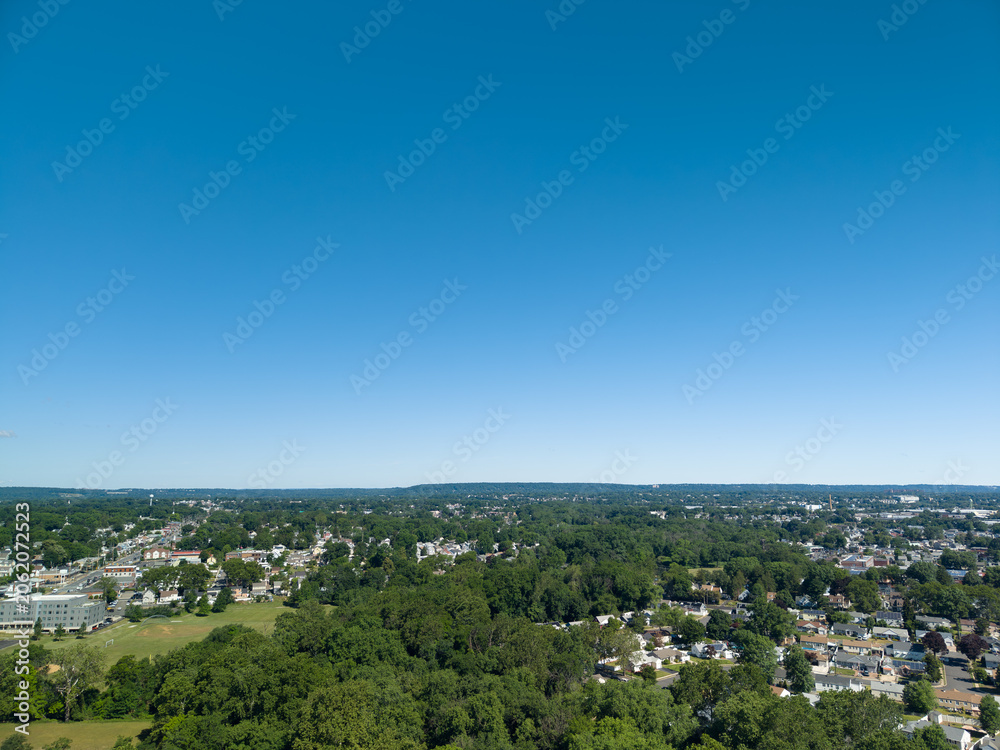 Obraz premium Suburban neighborhood with houses and green trees under clear blue sky