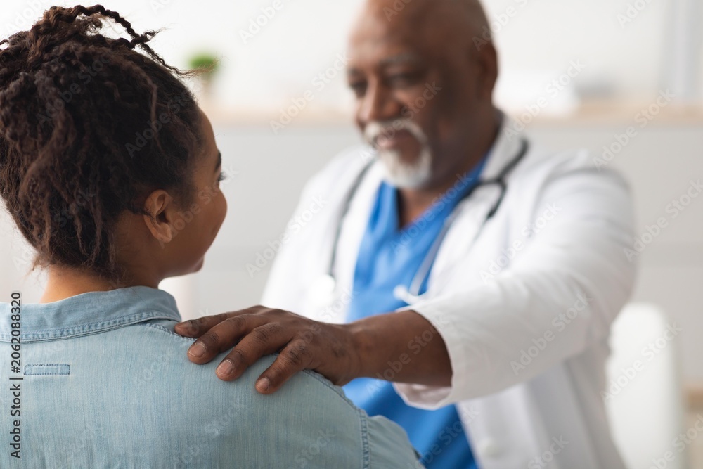 Fototapeta premium Caring And Supportive Doctor Showing Empathy To Black Female Patient During Consultation In Healthcare Clinic, Building Trust And Open Communication In Professional Setting. Healthcare Concept.