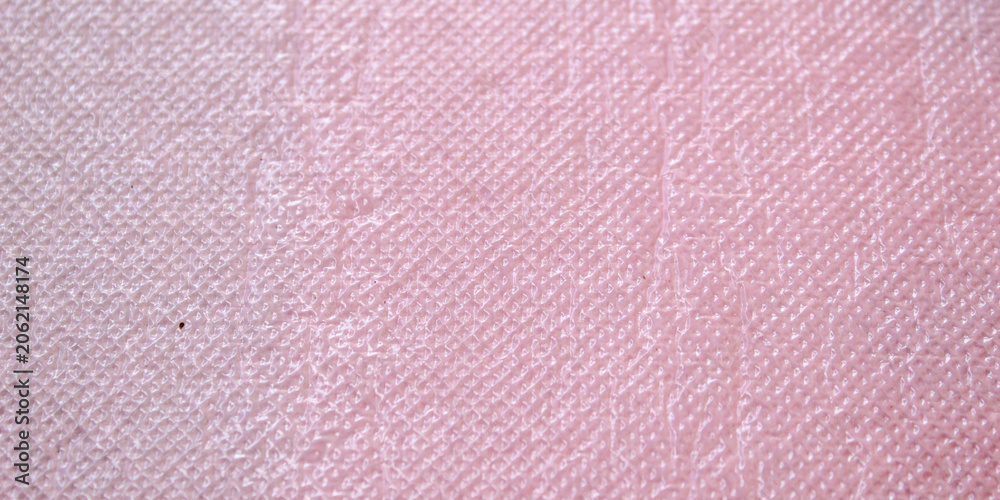 Fototapeta premium The surface texture of the plastic material is pink with a detailed embossed pattern.