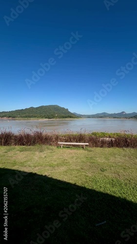 Scenic river viewpoint with benches and mountains under blue sky