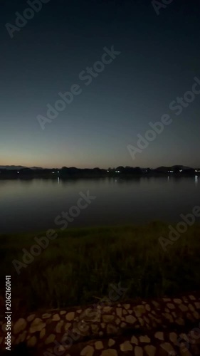 Vertical sunset pan over river and mountains from night view