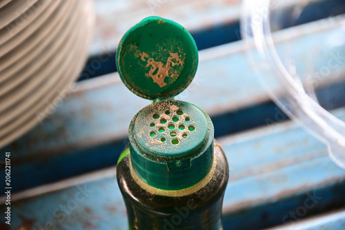Plastic cap, green container, opening, closeup, macro, dusty