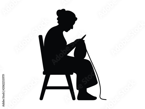 Silhouette of an elderly woman knitting in a chair