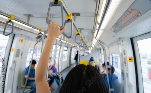 Woman hand firm grip safety handrail in elevated monorail train. Mass transit system in modern city. Inside of electric train. Tourist travel by city sky train. Public transportation. Urban transport.