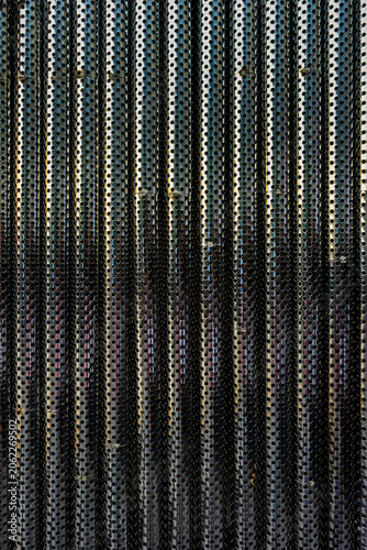 Abstract Background of Aligned Perforated Metal Pipes. A symmetrical pattern of industrial perforated stainless steel pipes, ideal for modern architectural, engineering and abstract design backgrounds