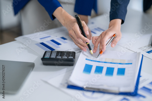 Collaborative business team analyzing financial documents and data charts