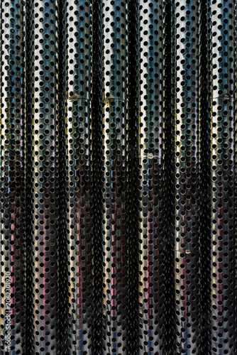 Abstract Symmetrical Background of Perforated Stainless Steel Pipes. Aligned perforated metal tubes, featuring a industrial pattern perfect for modern architectural, engineering and design backgrounds