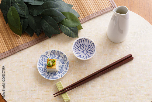 Japanese Sake Set with Chilled Tofu, Tokkuri, and Ochoko on a Bamboo Mat