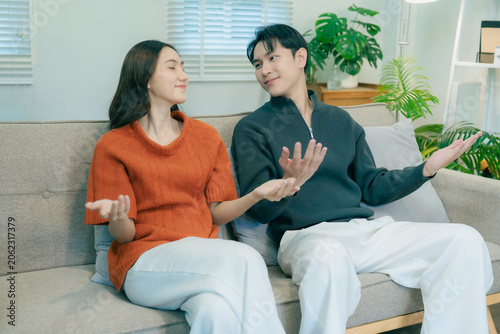 Tableau sur toile A happy young Asian couple sits together on a sofa at home