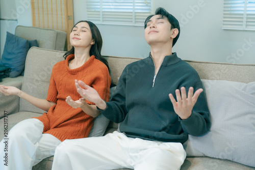 Tableau sur toile A happy young Asian couple sits together on a sofa at home