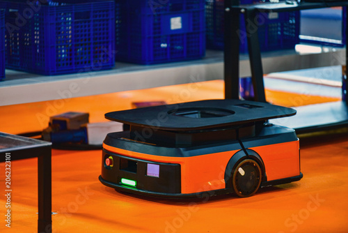 Autonomous mobile robot AMR navigating through modern smart warehouse floor.	
