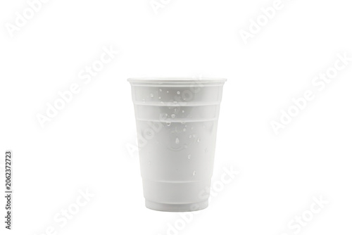 Translucent white plastic disposable cup with horizontal ridges and small water droplets on the exterior surface isolated on a transparent background