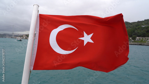 Red Turkish national flag with crescent and star fluttering on a cloudy day