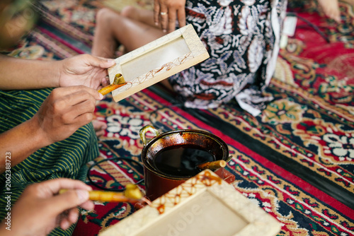 Φωτογραφία Skilled artist applying batik wax to a wooden picture frame, highlighting tradit