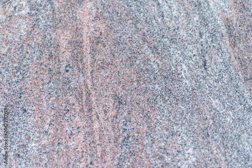 Fotografie Close-up of polished red granite stone texture with natural grey and black veins