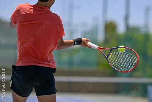 Tennis player hitting a forehand shot during an outdoor match