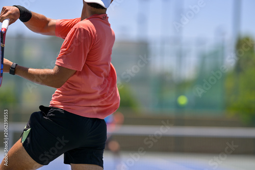Tennis player hitting a forehand shot during an outdoor match