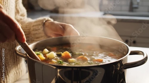 Soup Stewing in Pot with Steam Rising In Kitchen
